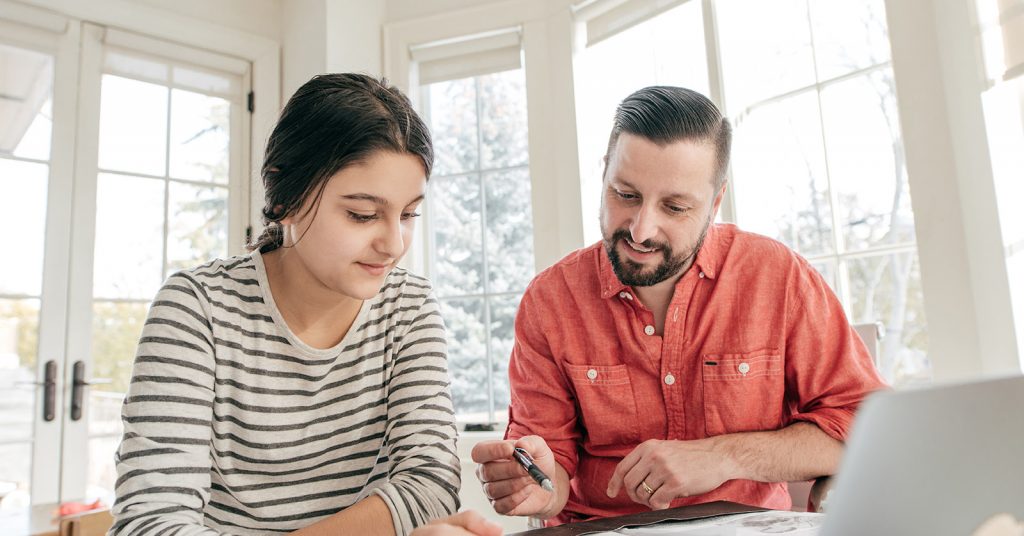 Father and daughter looking at laptop