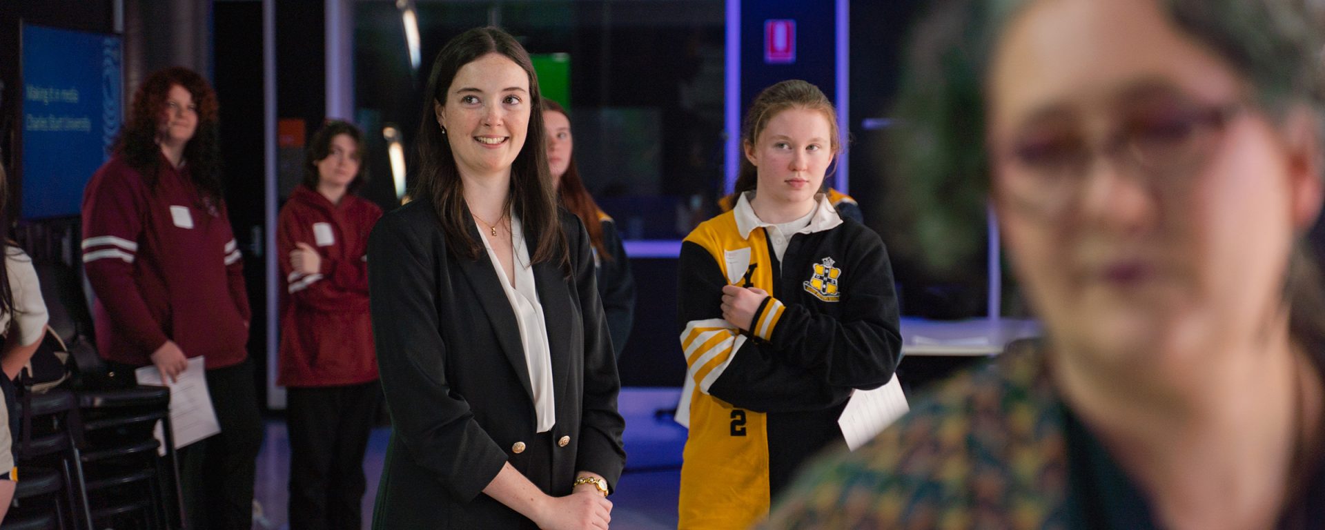 A female newsreader stands in the Comms precinct of Charles Sturt's Bathurst campus