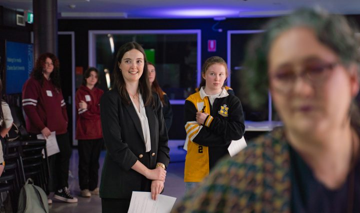 A female newsreader stands in the Comms precinct of Charles Sturt's Bathurst campus