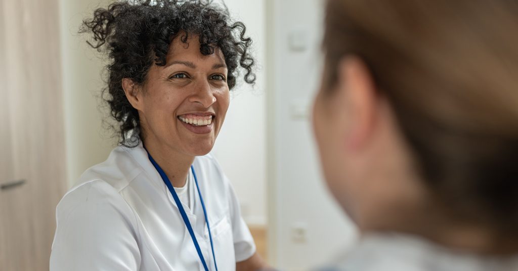 Woman smiling talking to another woman